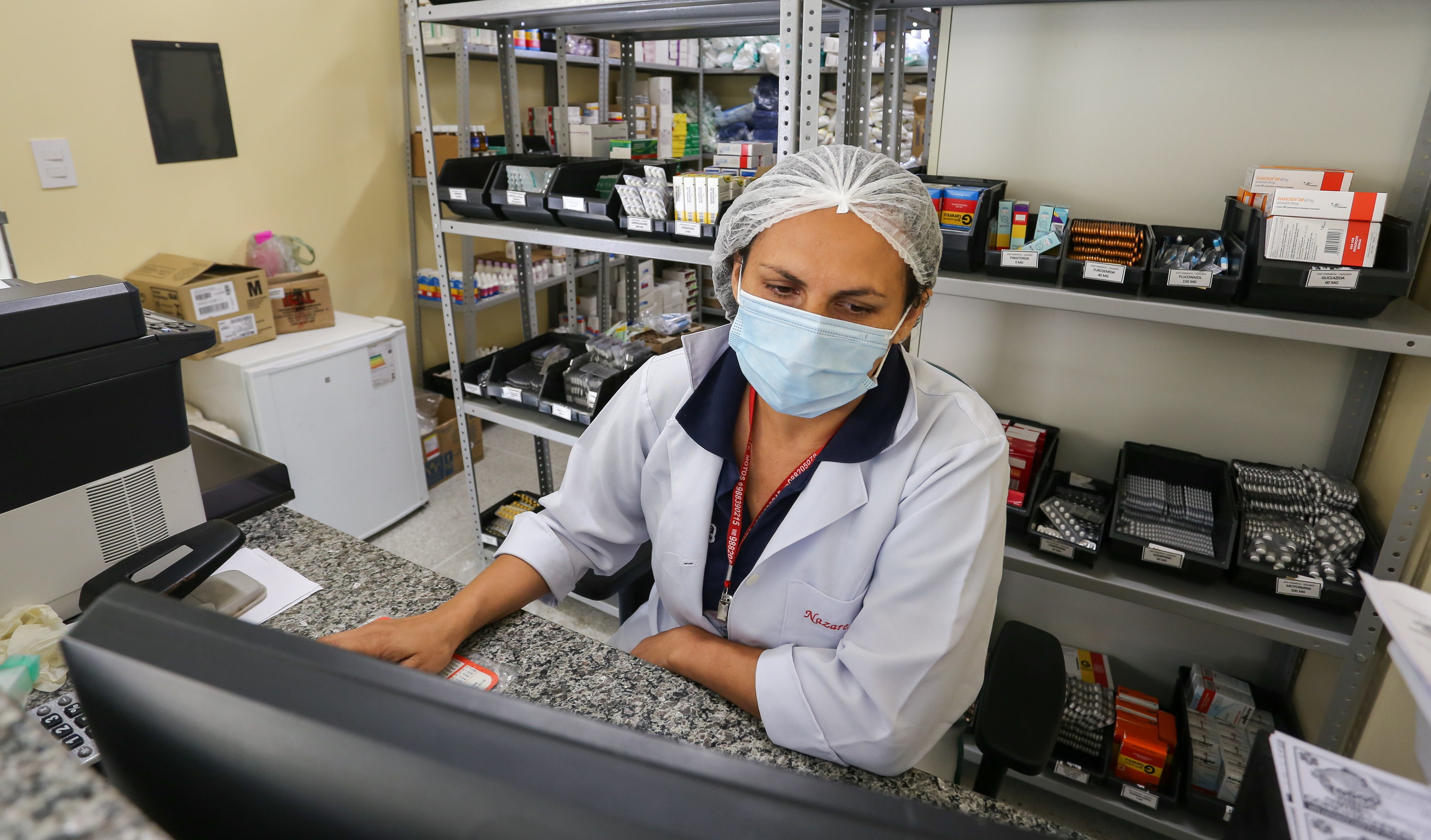 funcionária do posto de saúde na farmácia do equipamento